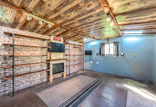 basement with rail lighting and brick wall