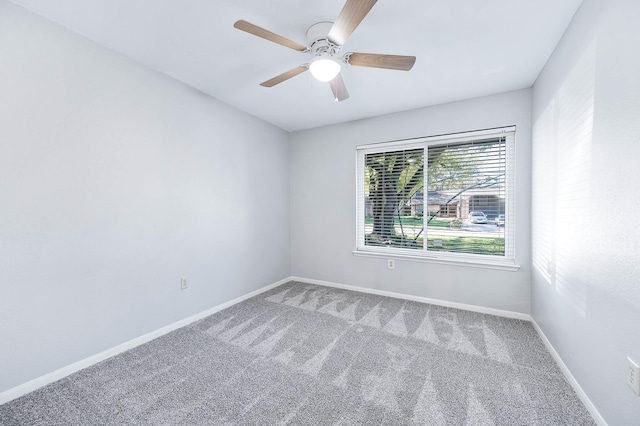 spare room with ceiling fan and carpet