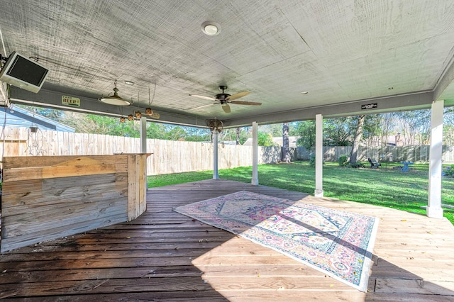 wooden deck with ceiling fan and a yard