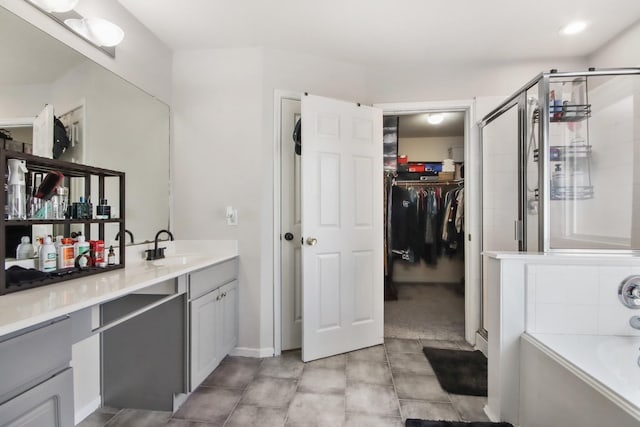 bathroom featuring vanity and independent shower and bath