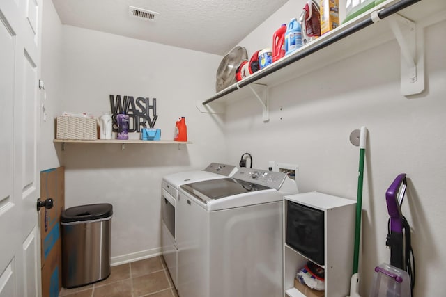 washroom featuring light tile patterned flooring and washing machine and clothes dryer