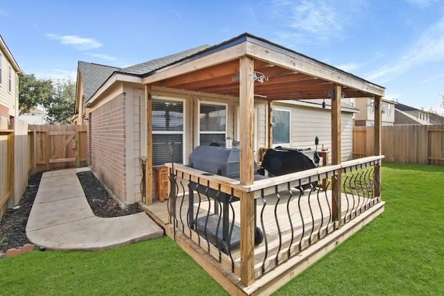 deck featuring a lawn and grilling area