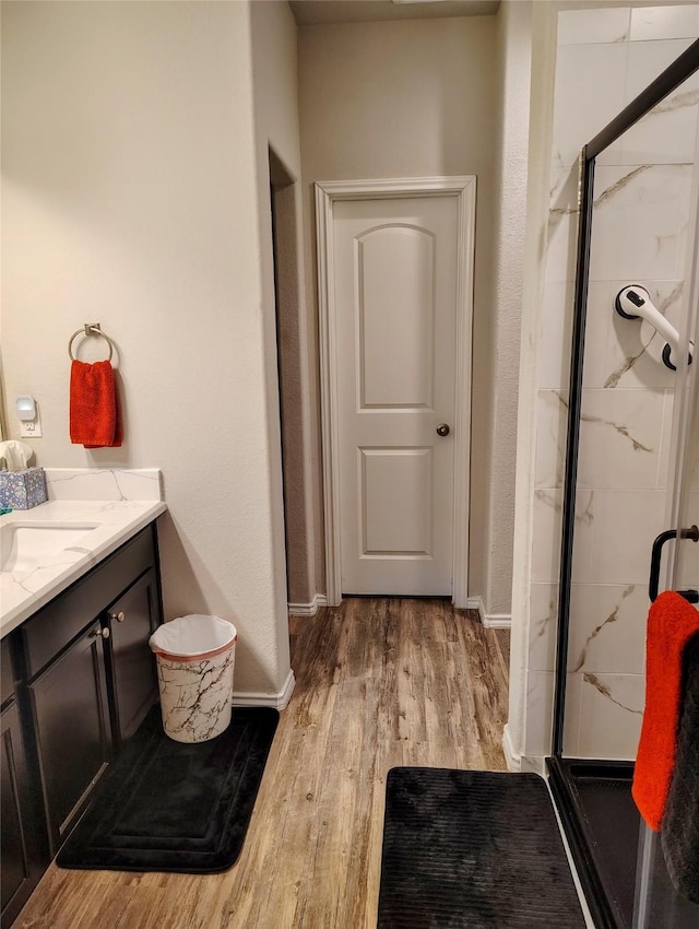 bathroom featuring hardwood / wood-style floors, vanity, and walk in shower