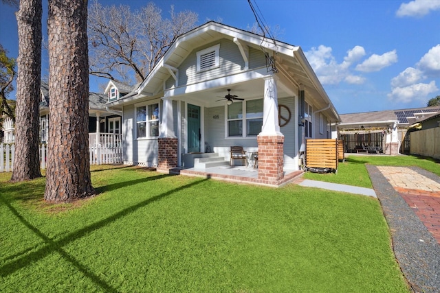 back of house featuring ceiling fan and a yard