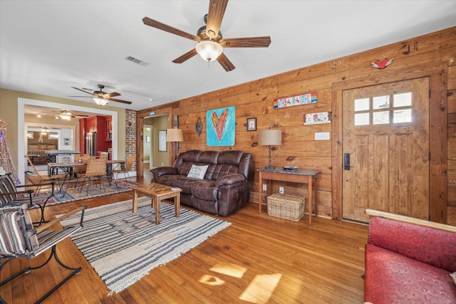 living room with wooden walls and light wood-type flooring