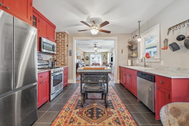 kitchen with sink, dark tile patterned floors, stainless steel appliances, and plenty of natural light