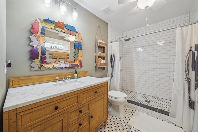 bathroom with a shower with curtain, vanity, ceiling fan, and toilet