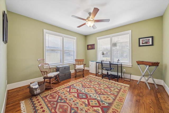 living area with ceiling fan and dark hardwood / wood-style floors