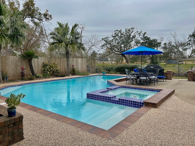 view of swimming pool with an in ground hot tub and a patio