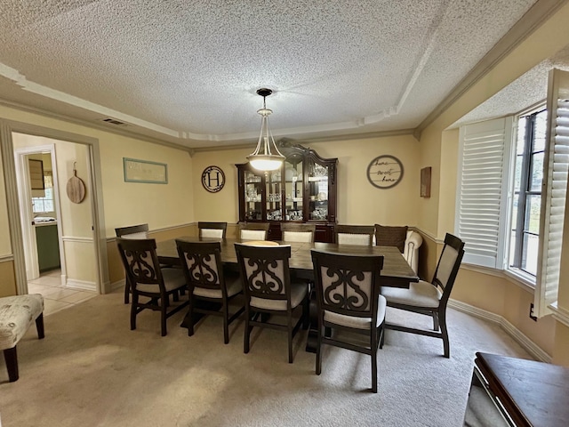 dining space with light colored carpet and a textured ceiling