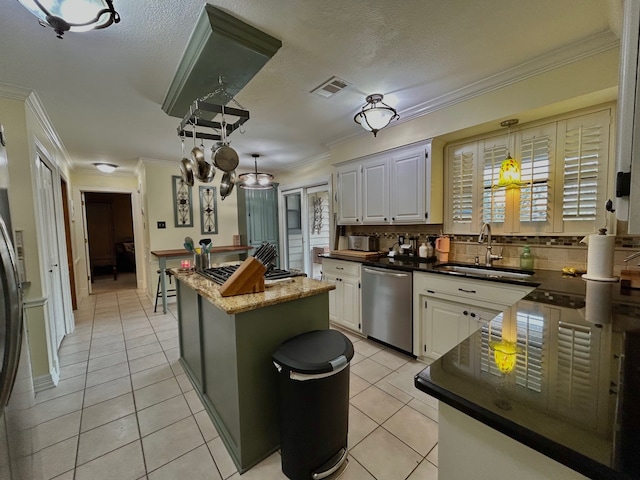 kitchen featuring a kitchen island, white cabinetry, sink, and appliances with stainless steel finishes