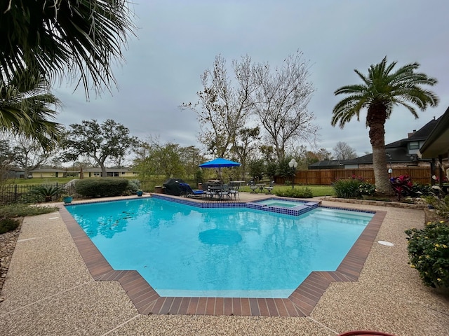 view of pool with an in ground hot tub