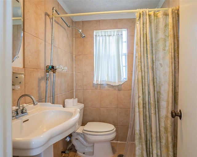 bathroom featuring a textured ceiling, toilet, tile walls, and sink