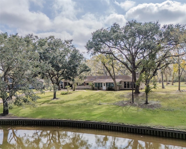 view of front of property with a front lawn and a water view