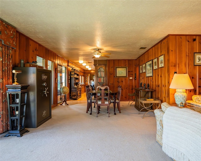 dining area featuring ceiling fan, carpet floors, and a textured ceiling