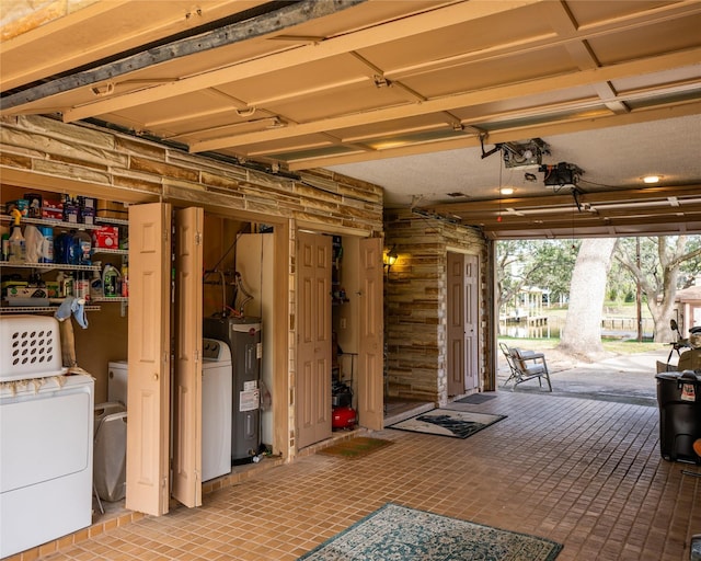 garage with electric water heater and washing machine and clothes dryer