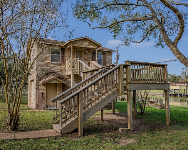 view of jungle gym featuring a deck with water view and a yard