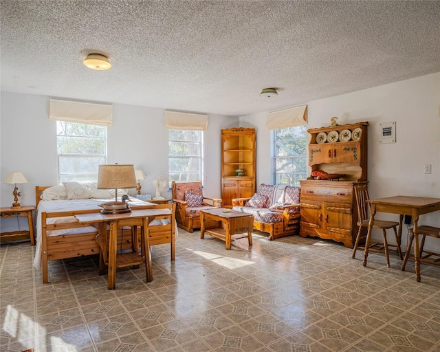 bedroom with a textured ceiling and multiple windows