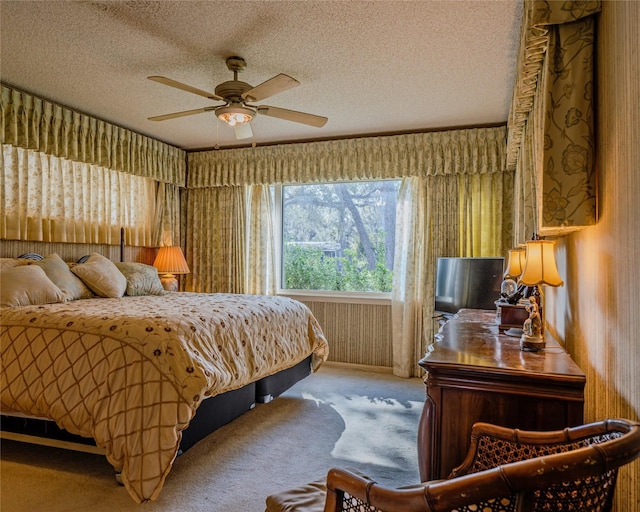 carpeted bedroom with ceiling fan and a textured ceiling