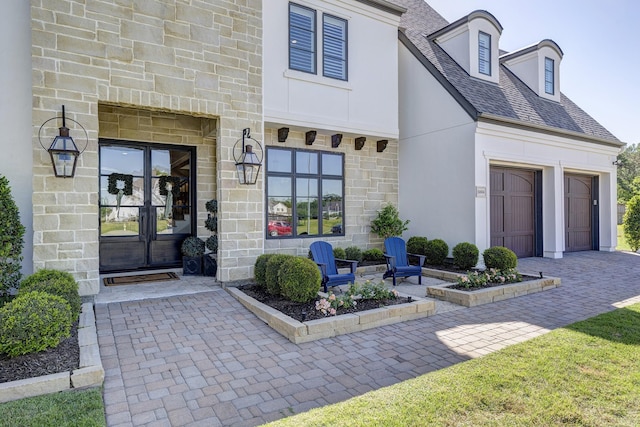 view of exterior entry with french doors and a garage