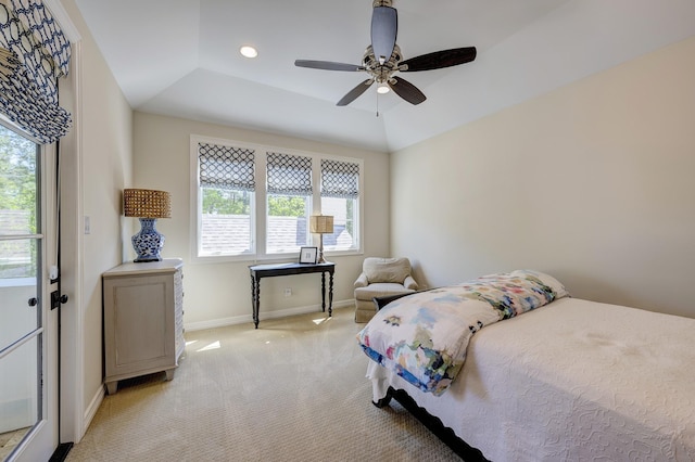 carpeted bedroom featuring a raised ceiling, multiple windows, and ceiling fan