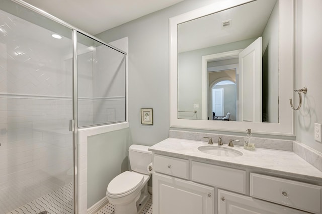 bathroom with toilet, vanity, and walk in shower