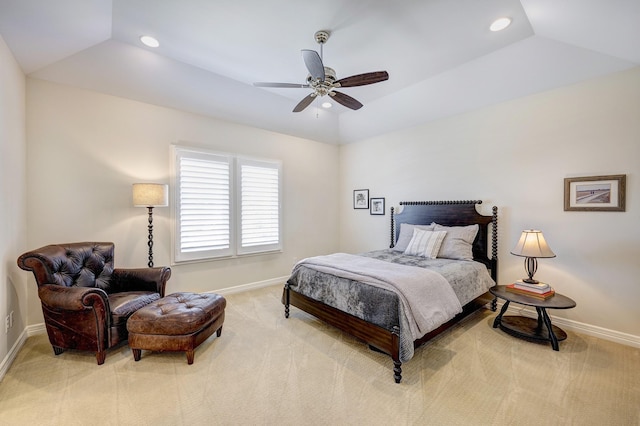 bedroom with ceiling fan, a raised ceiling, light colored carpet, and vaulted ceiling