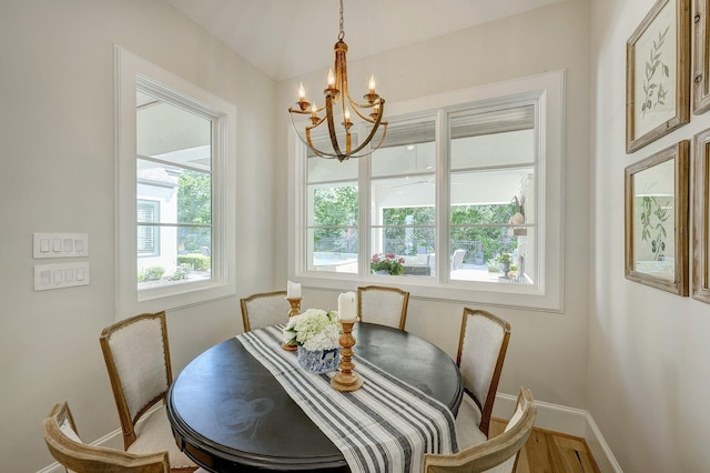 dining room featuring wood-type flooring and an inviting chandelier