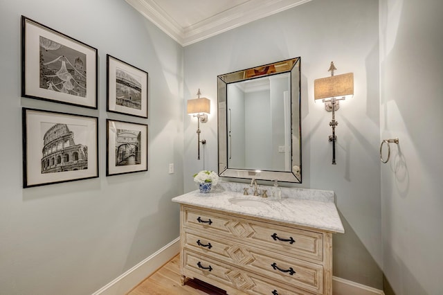 bathroom with hardwood / wood-style flooring, vanity, and ornamental molding