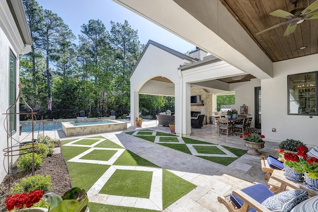 view of patio / terrace with a fenced in pool, ceiling fan, and an outdoor living space with a fireplace