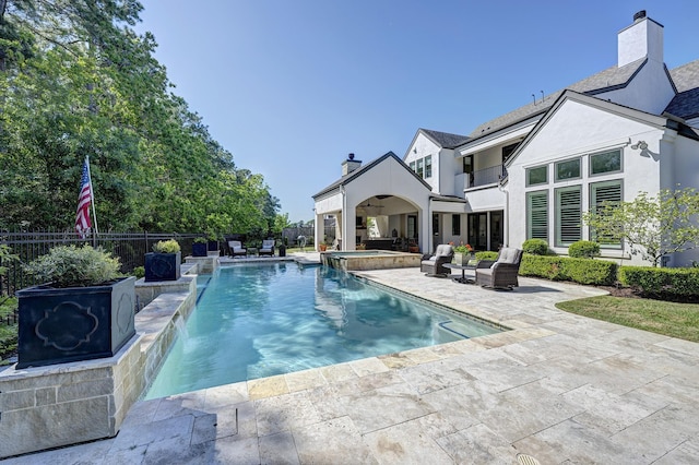 view of pool with pool water feature, a patio, and an in ground hot tub