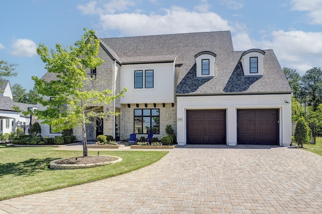 french country inspired facade featuring a front lawn and a garage