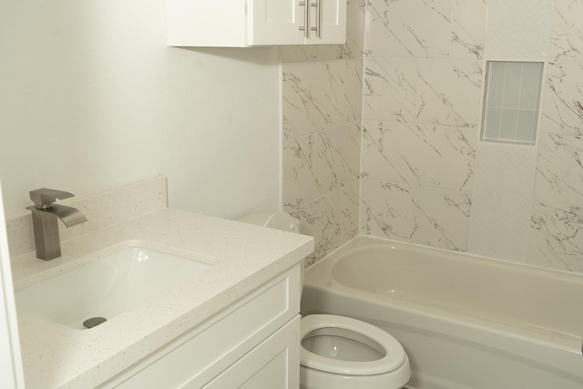 full bathroom featuring vanity, tiled shower / bath combo, and toilet