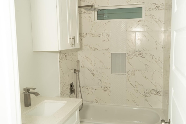 bathroom featuring vanity and tiled shower / bath