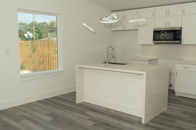 kitchen featuring white cabinets, decorative light fixtures, and sink