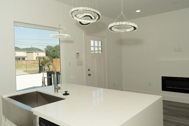 kitchen featuring light stone countertops, sink, hanging light fixtures, and a chandelier