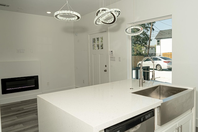 kitchen featuring sink, dishwasher, an inviting chandelier, decorative light fixtures, and a kitchen island