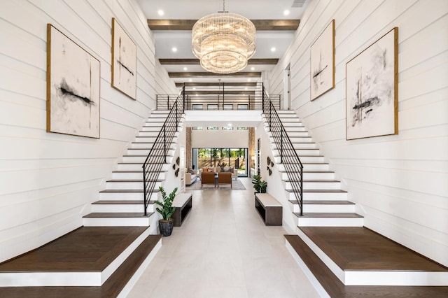 foyer with wood walls, beamed ceiling, and an inviting chandelier