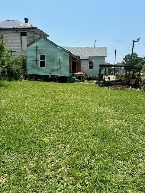 rear view of property featuring a yard