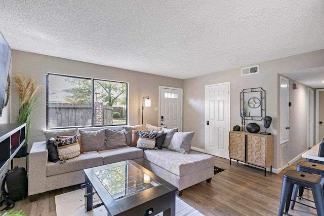 living room featuring wood-type flooring and a textured ceiling