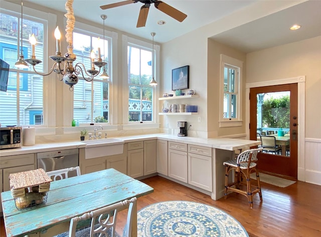 kitchen featuring pendant lighting, light wood-type flooring, sink, and appliances with stainless steel finishes