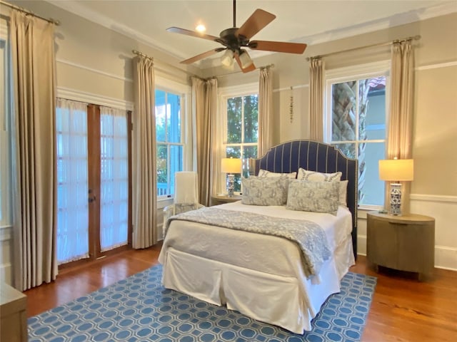 bedroom with ceiling fan, wood-type flooring, and ornamental molding