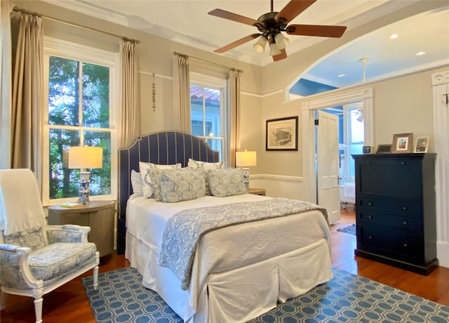 bedroom with ensuite bath, ceiling fan, hardwood / wood-style floors, and crown molding