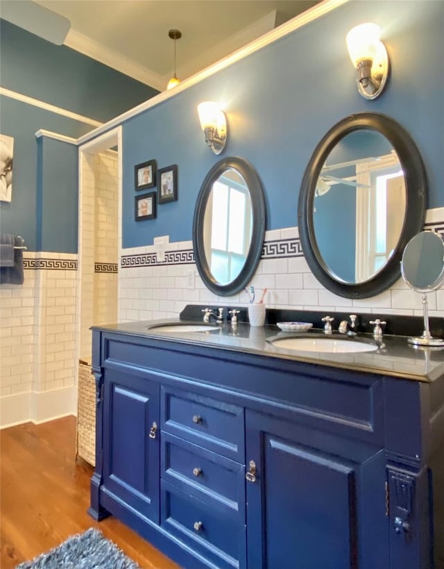 bathroom featuring wood-type flooring, vanity, tile walls, and crown molding