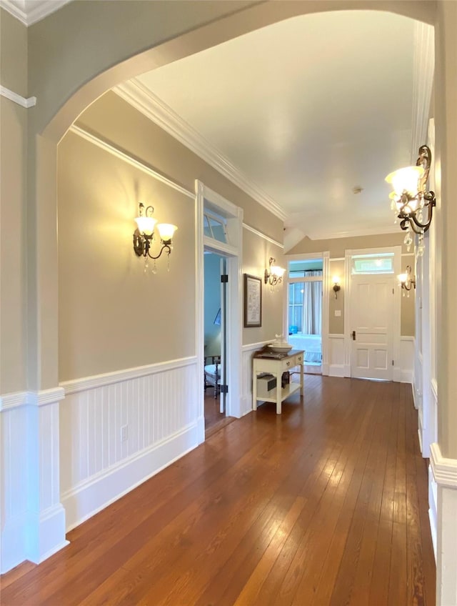 interior space with dark hardwood / wood-style flooring, crown molding, and an inviting chandelier