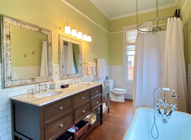 full bathroom with ornamental molding, vanity, hardwood / wood-style flooring, tile walls, and toilet