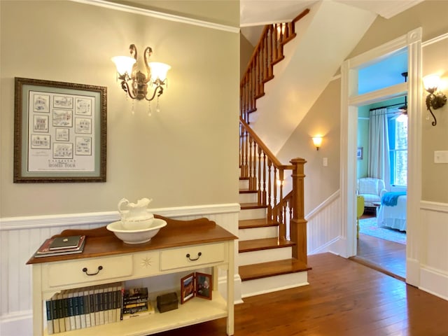 stairs with hardwood / wood-style floors and a chandelier