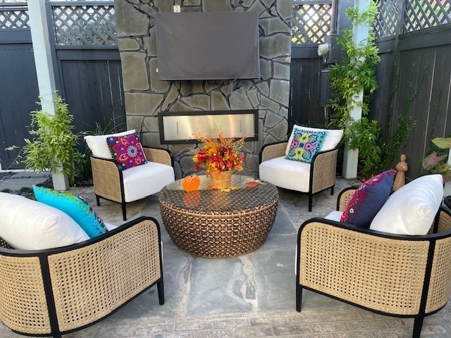 balcony with an outdoor living space with a fireplace and a patio area