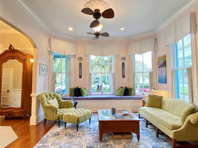 sitting room featuring hardwood / wood-style floors, ceiling fan, and crown molding