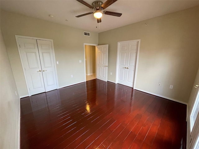 unfurnished bedroom with dark hardwood / wood-style floors and ceiling fan